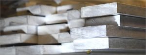 Stack of magnesium metal bars used in aerospace machining, highlighting lightweight raw material ready for precision fabrication.