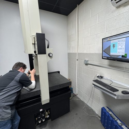Technician performing CMM inspection on precision-machined aerospace component